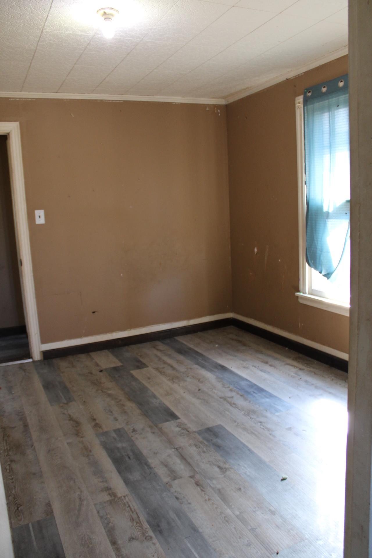 1027 Lynn School Road Ripley, TN 38063 - Photo 13 of 26 a view of an empty room with wooden floor and a window