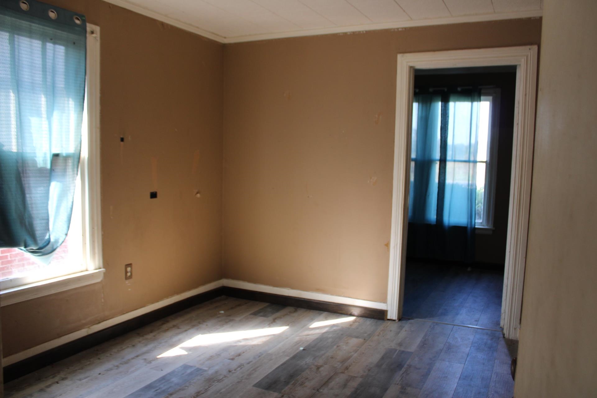 1027 Lynn School Road Ripley, TN 38063 - Photo 18 of 26 a view of an empty room with wooden floor and a window