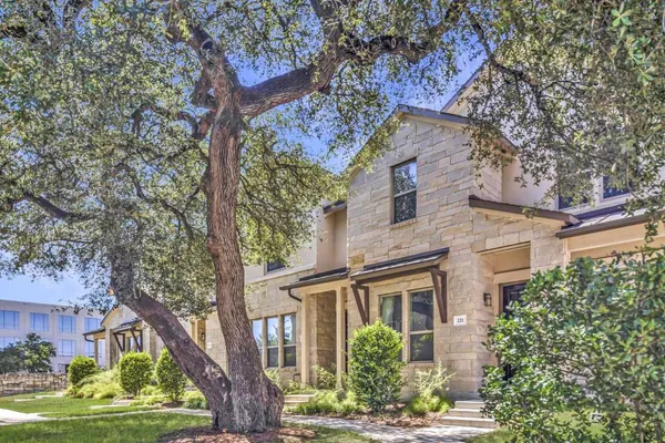 front view of a house with a large tree