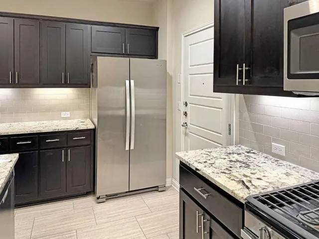 a kitchen with granite countertop stove and cabinets
