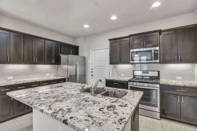 a kitchen that has a sink and a stove in it