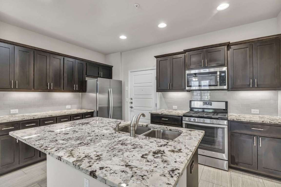 13800 Lyndhurst Street, Unit 223 Austin, TX 78717 - Photo 12 of 40 a kitchen with stainless steel appliances granite countertop a sink stove and refrigerator
