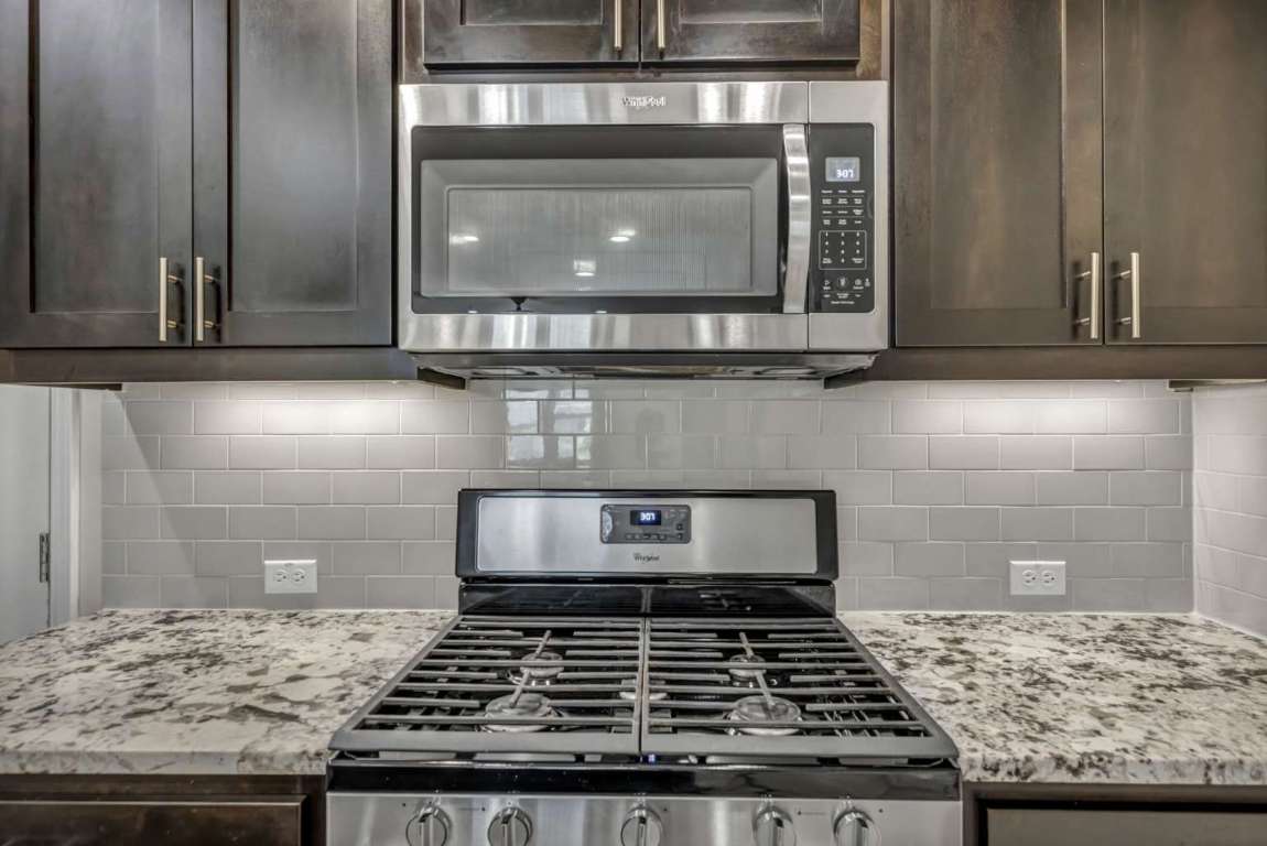 13800 Lyndhurst Street, Unit 223 Austin, TX 78717 - Photo 13 of 40 a kitchen with granite countertop stove and cabinets