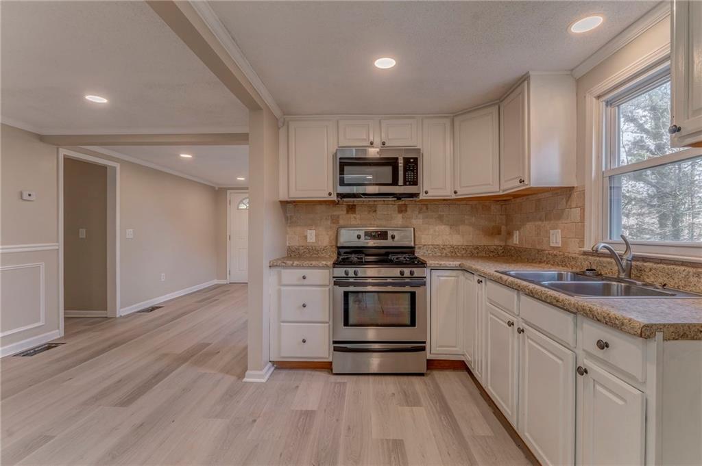 653 Fairview Road Ball Ground, GA 30107 - Photo 25 of 52 a kitchen with stainless steel appliances granite countertop a stove a sink and a microwave