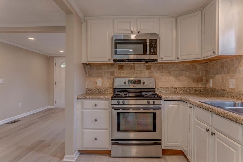 653 Fairview Road Ball Ground, GA 30107 - Photo 26 of 52 a kitchen with stainless steel appliances granite countertop a stove microwave and sink