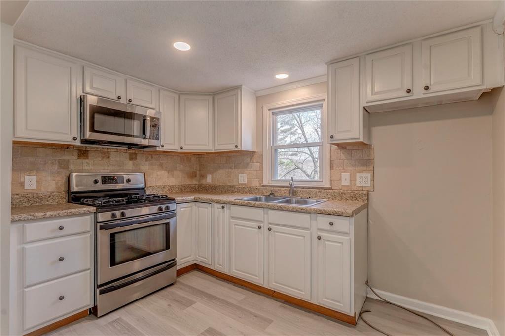 653 Fairview Road Ball Ground, GA 30107 - Photo 27 of 52 a kitchen with stainless steel appliances granite countertop a stove a sink and a microwave