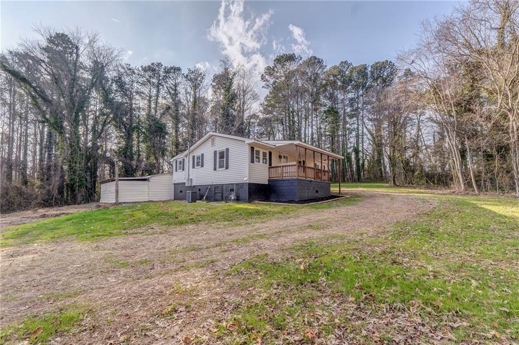 653 Fairview Road Ball Ground, GA 30107 - Photo 4 of 52 a view of a house with backyard and trees