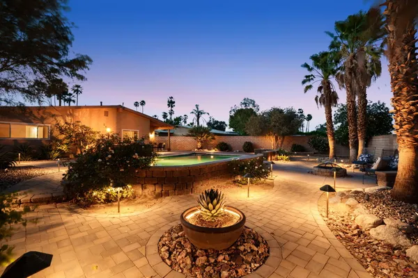 a view of a swimming pool with a patio and a fire pit