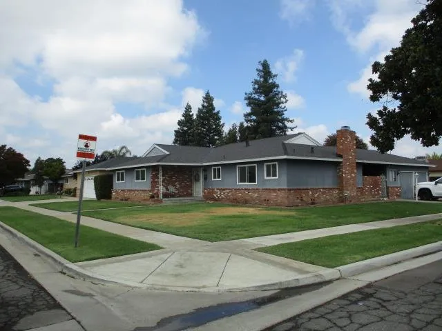 a front view of a house with a yard and trees