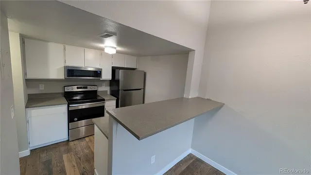 a kitchen with a refrigerator and a stove top oven