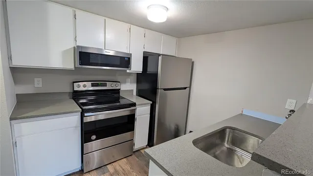 a kitchen with a refrigerator sink and stove