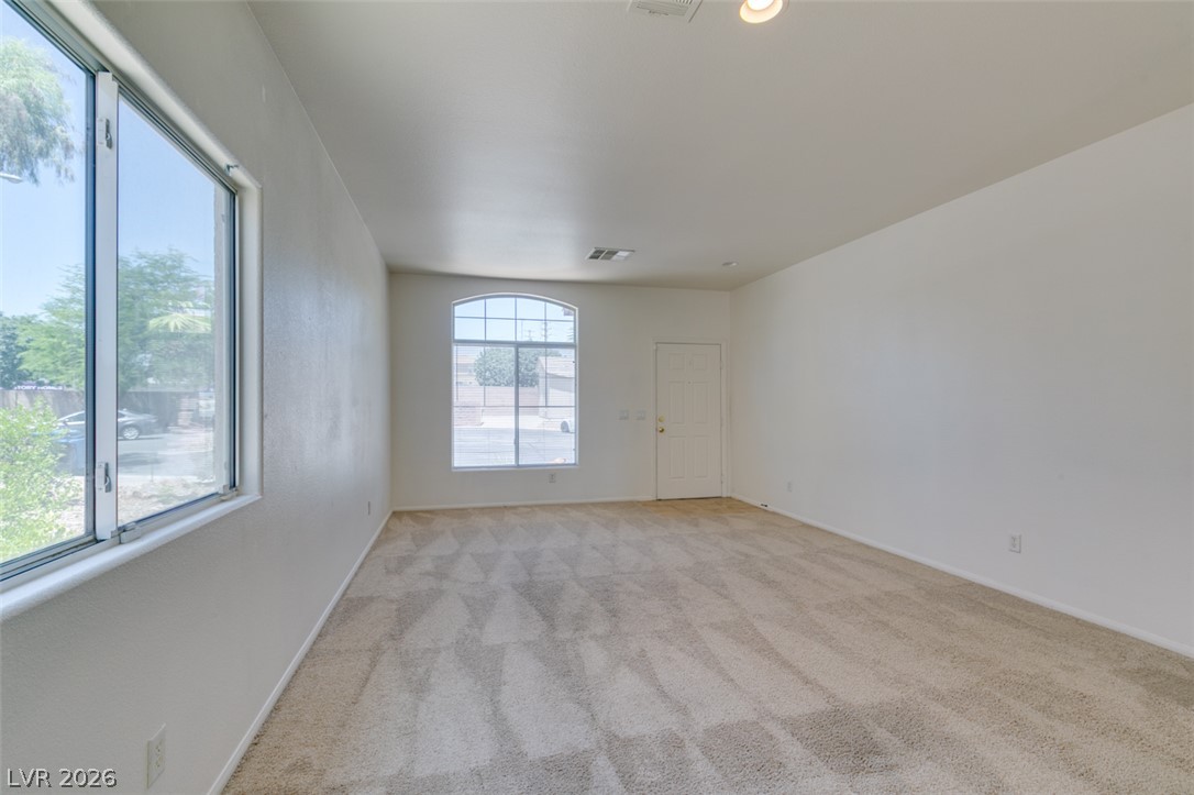 5150 Riverside Run Court North Las Vegas, NV 89081 - Photo 15 of 50 A sun-filled living space awaits, featuring soft carpeting and a welcoming entry.
