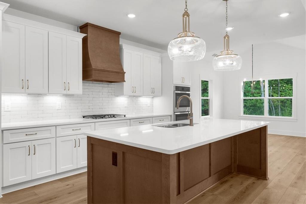 502 Level Creek Road Sugar Hill, GA 30518 - Photo 14 of 54 a kitchen with a sink dishwasher and white cabinets with wooden floor