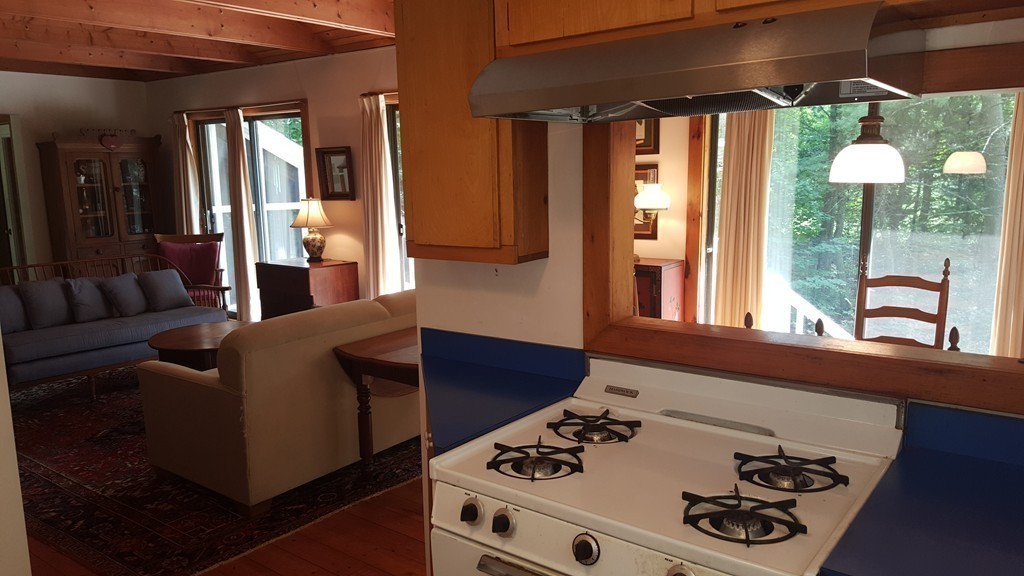 9 Pine Tree Circle Pelham, MA 01002 - Photo 15 of 30 a kitchen with stainless steel appliances granite countertop a stove a sink and a dining table with wooden floor