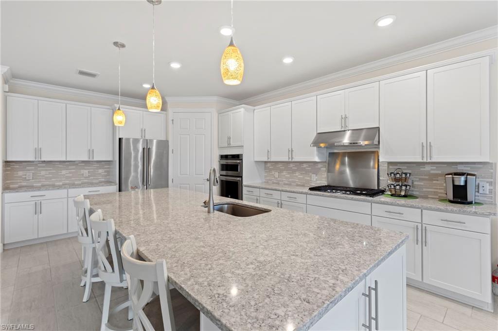 10530 Jackson Square Drive Estero, FL 33928 - Photo 11 of 48 a kitchen with kitchen island granite countertop a sink and cabinets