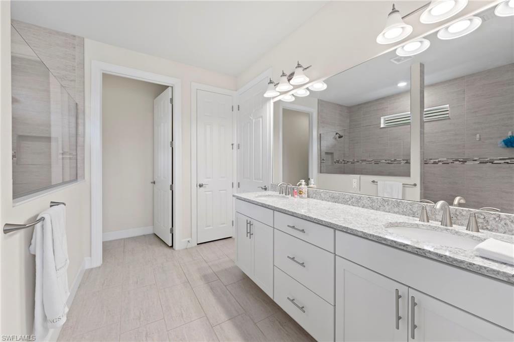 10530 Jackson Square Drive Estero, FL 33928 - Photo 23 of 48 a spacious bathroom with a granite countertop sink a mirror and a shower