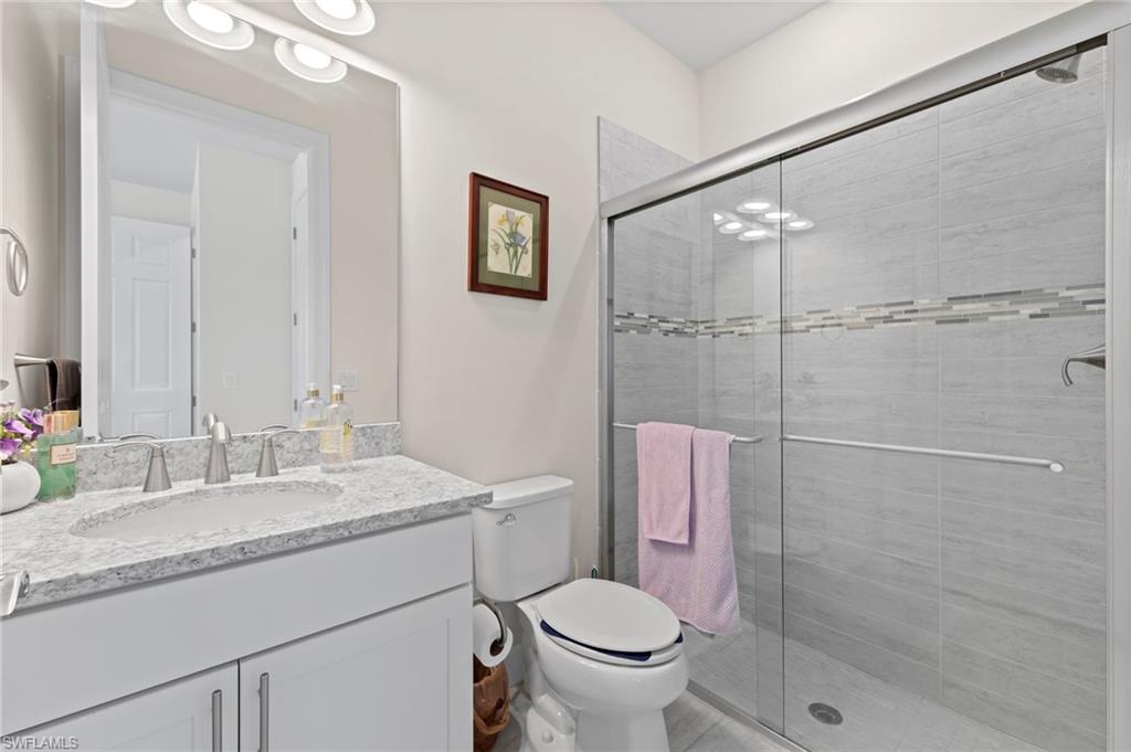 10530 Jackson Square Drive Estero, FL 33928 - Photo 27 of 48 a bathroom with a granite countertop sink toilet and shower