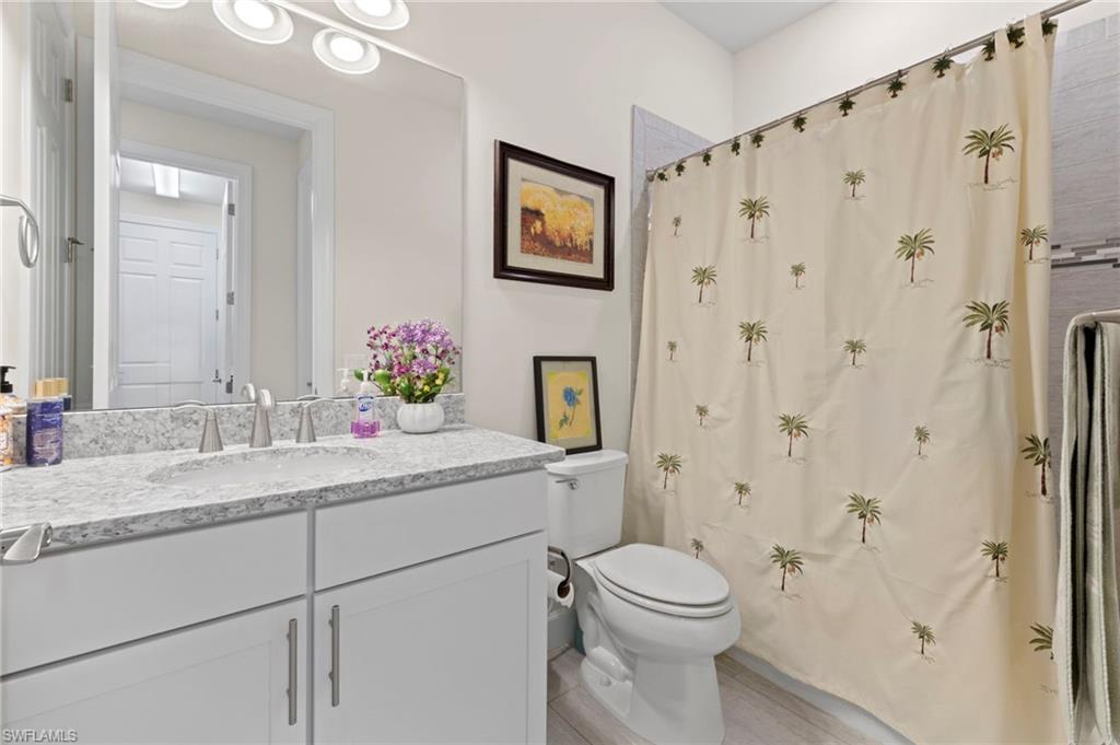 10530 Jackson Square Drive Estero, FL 33928 - Photo 30 of 48 a bathroom with a granite countertop sink toilet and shower