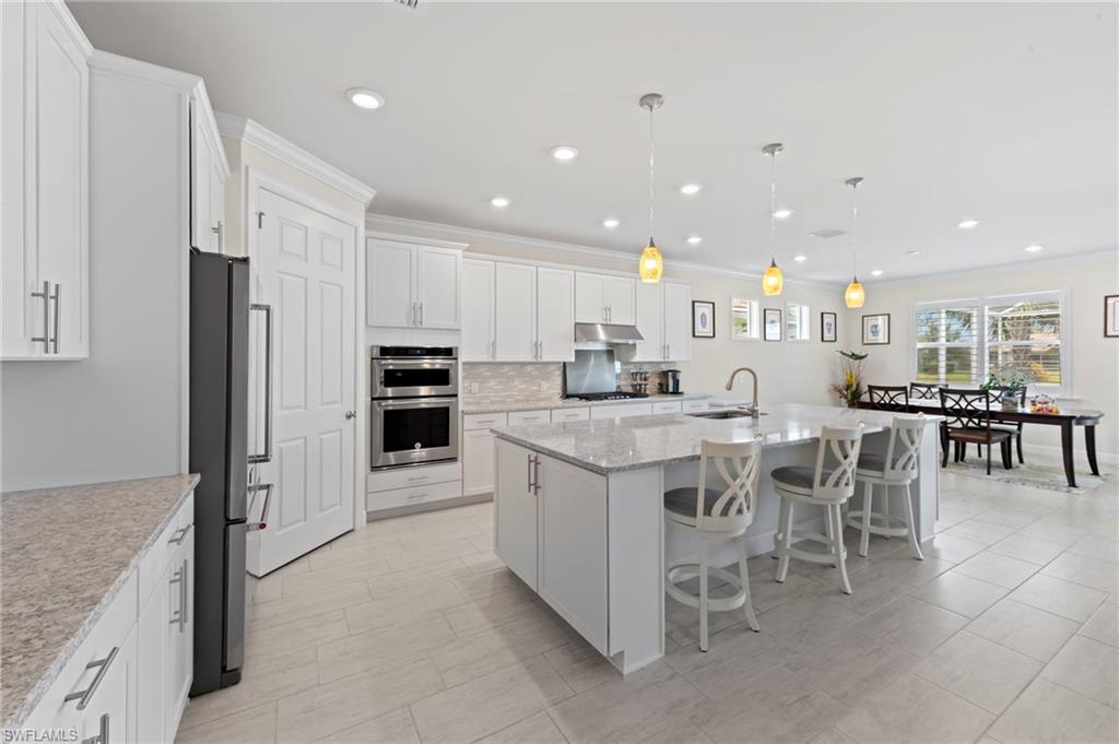 10530 Jackson Square Drive Estero, FL 33928 - Photo 10 of 48 a kitchen with stainless steel appliances granite countertop a table and chairs in it