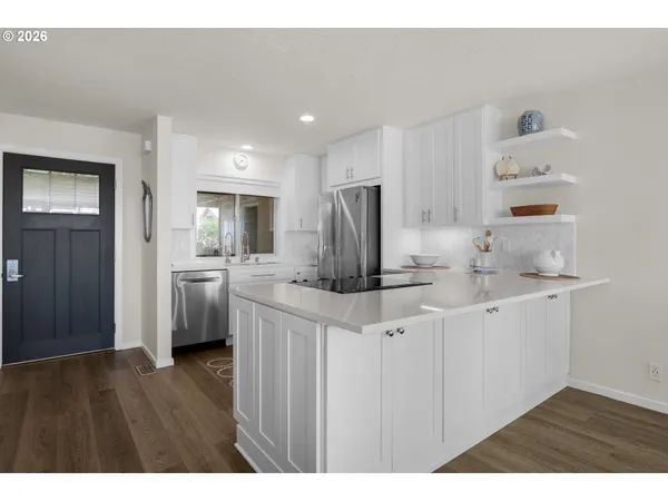 a kitchen with a table chairs refrigerator and cabinets