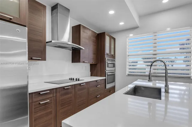 a kitchen with stainless steel appliances a sink a stove and a refrigerator