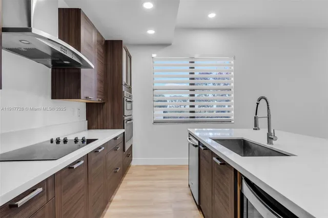 a kitchen with stainless steel appliances a sink a stove and a refrigerator