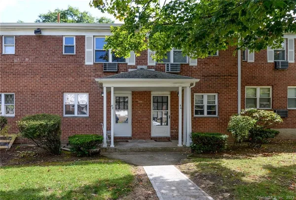 front view of a brick house with a yard