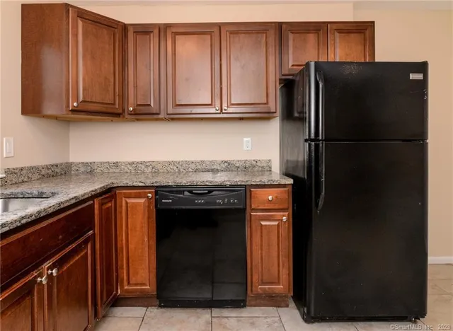 a kitchen with stainless steel appliances granite countertop a refrigerator and a stove