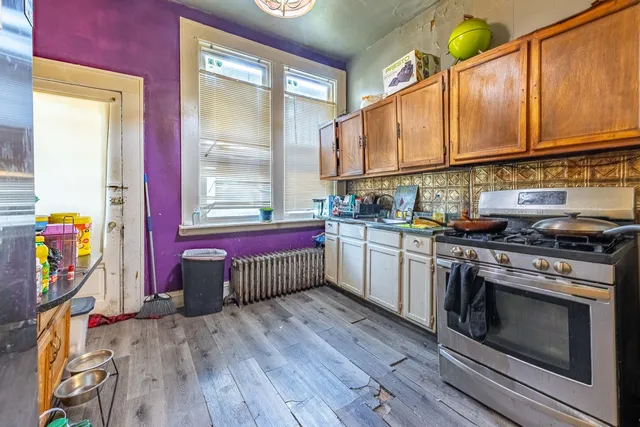 a kitchen that has a lot of cabinets in it and wooden floor