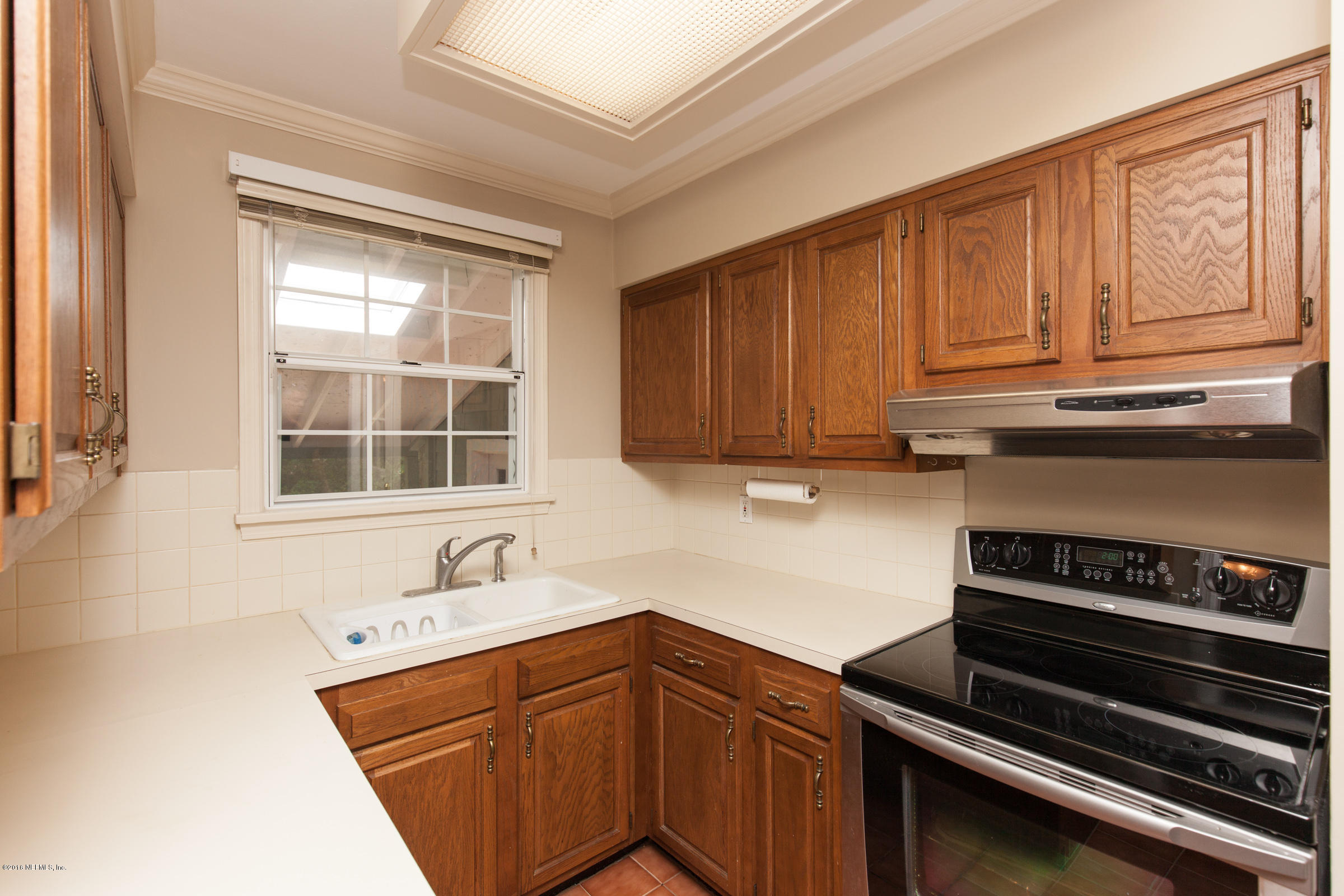 5432 Duke Road Jacksonville, FL 32207 - Photo 3 of 18 a kitchen with wooden cabinets stove and sink