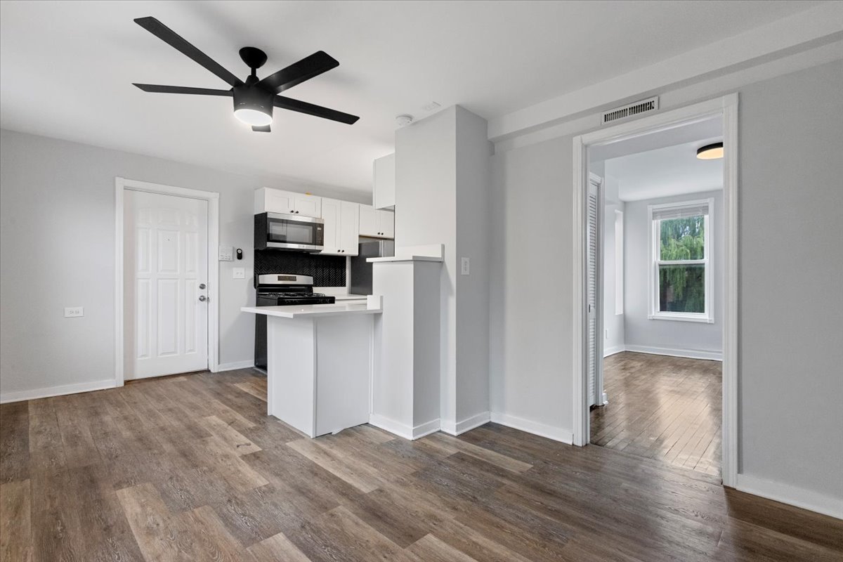 1849 West Augusta Boulevard, Unit 3 Chicago, IL 60622 - Photo 5 of 11 a view of a kitchen with wooden floor and a ceiling fan