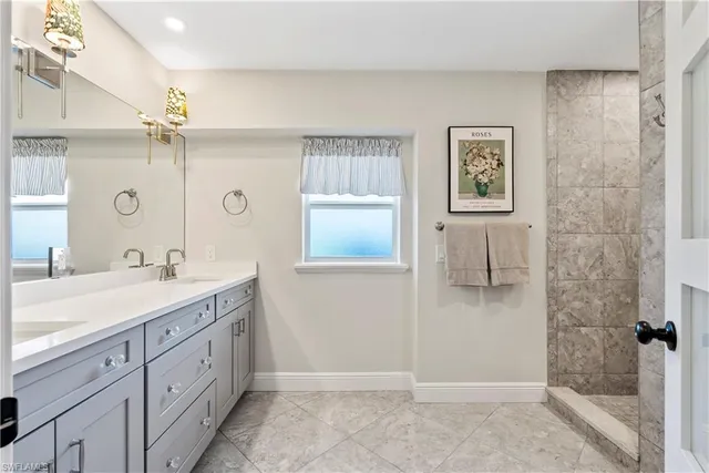 a spacious bathroom with a shower a sink and a mirror