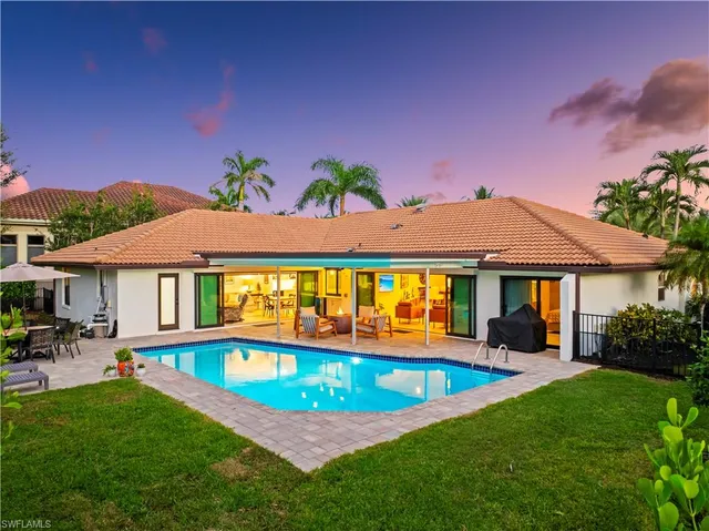 a backyard of a house with table and chairs
