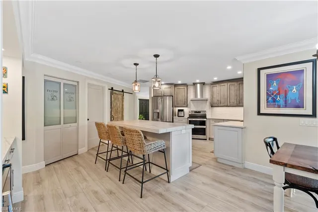 a kitchen with stainless steel appliances kitchen island granite countertop a dining table chairs and granite counter tops