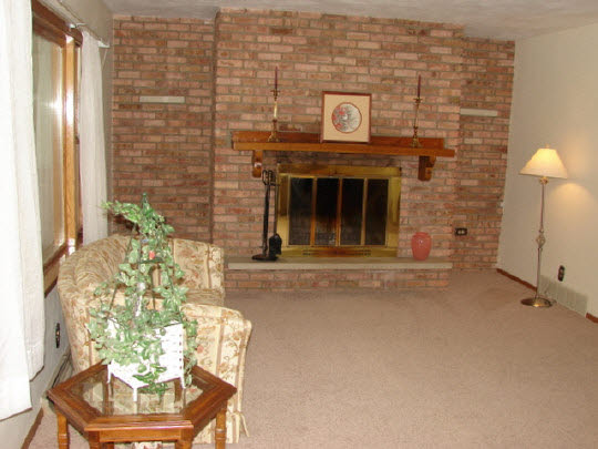 6911 Halley Road Rockford, IL 61101 - Photo 7 of 11 a living room with a fireplace and a chandelier