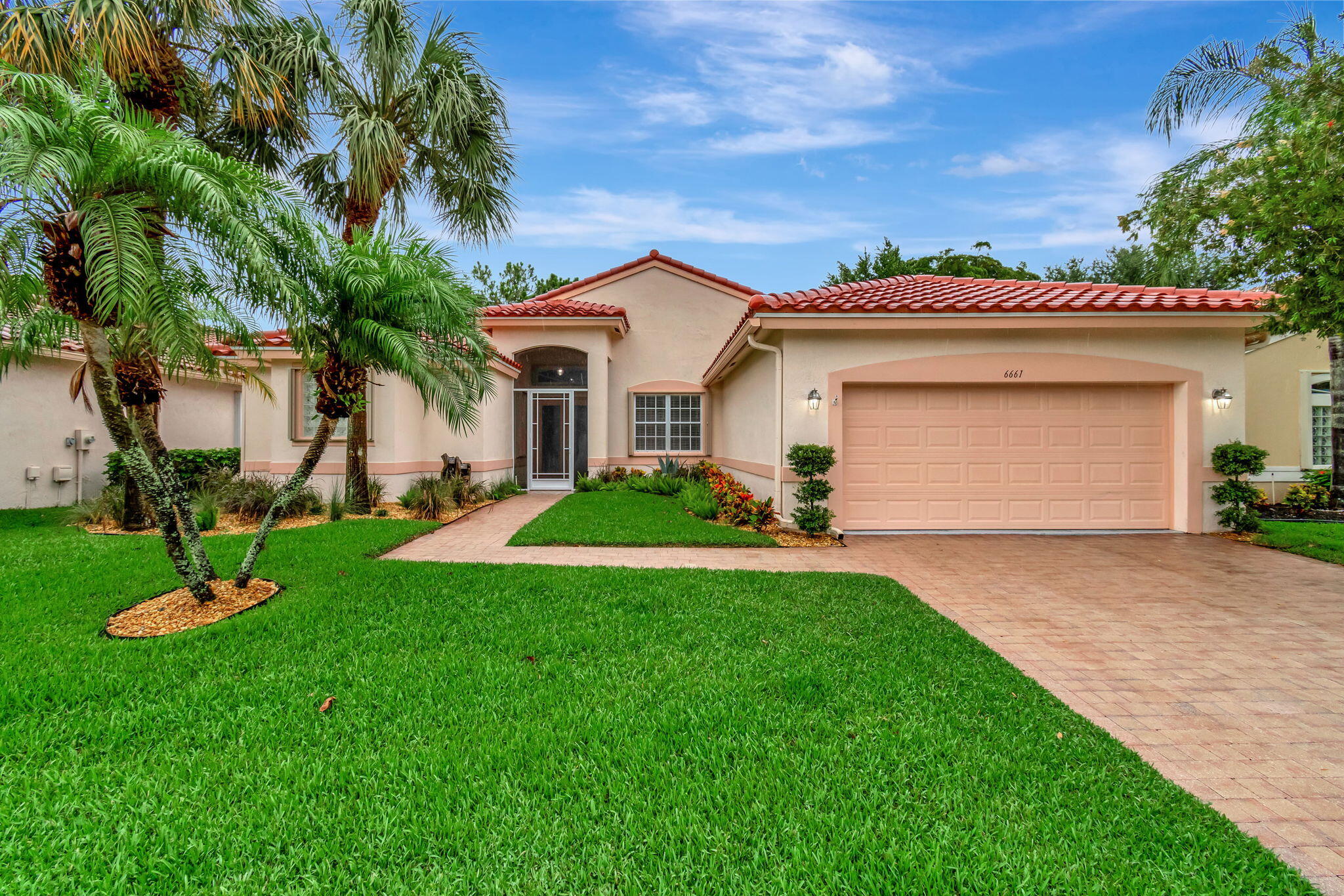6661 Garde Road Boynton Beach, FL 33472 - Photo 26 of 48 a front view of a house with a yard and garage