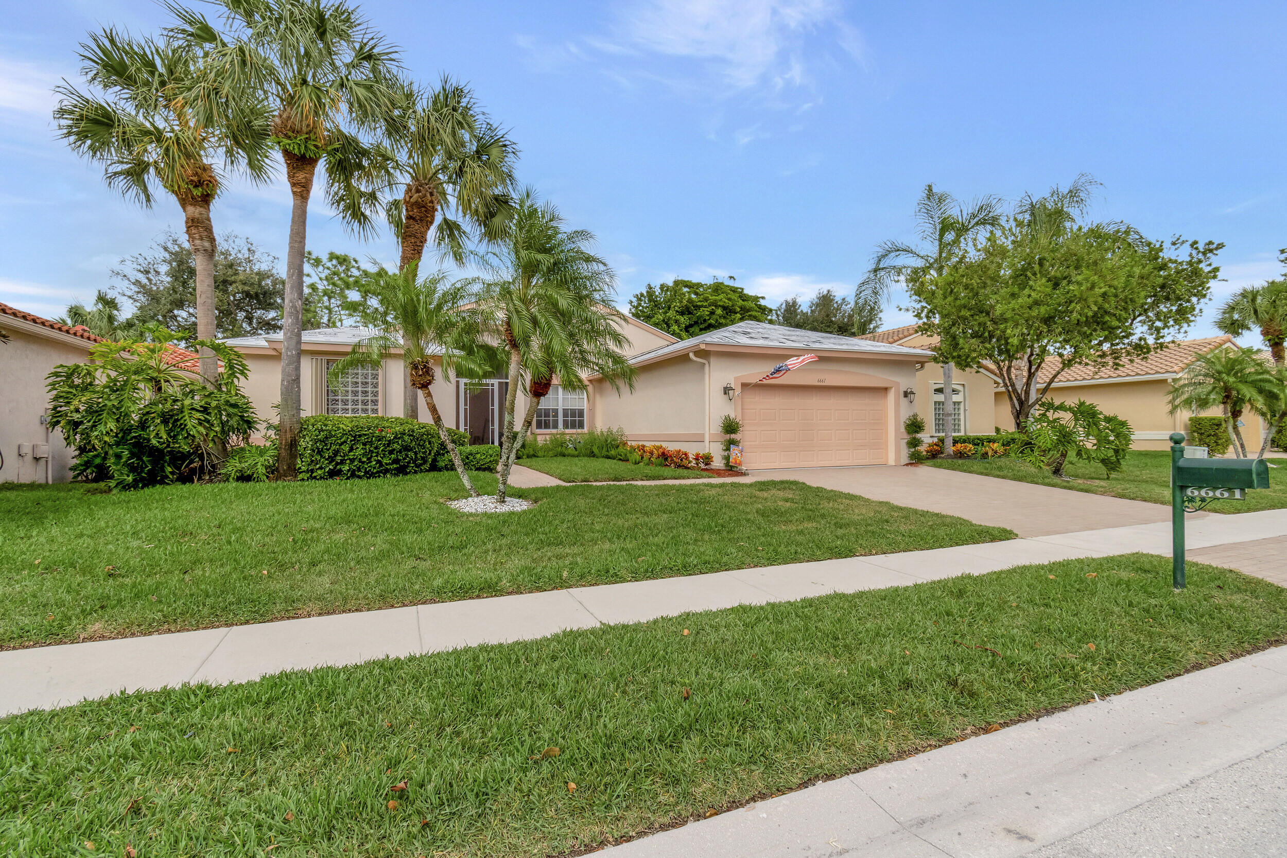 6661 Garde Road Boynton Beach, FL 33472 - Photo 27 of 48 a front view of a house with a garden and tree