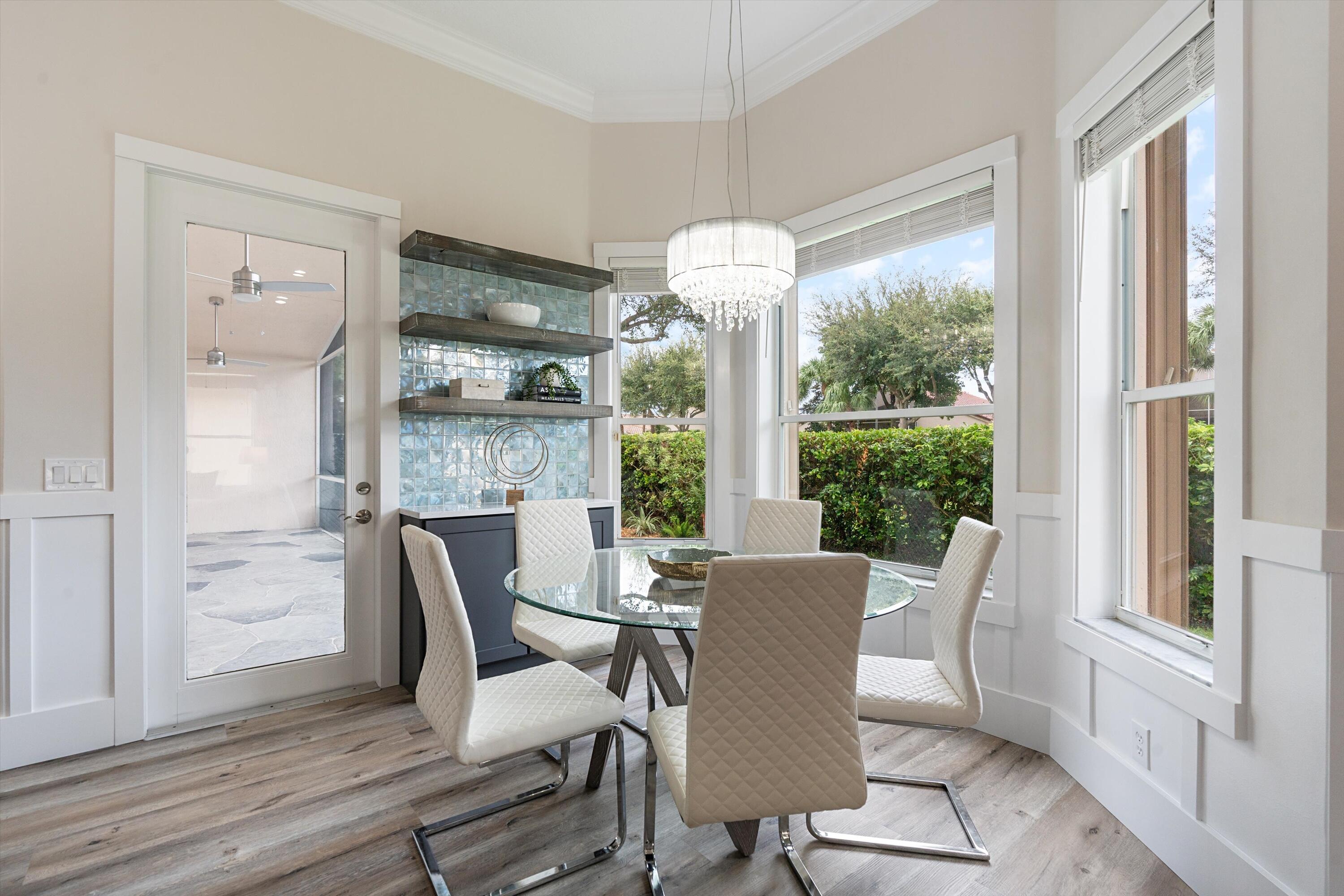 6661 Garde Road Boynton Beach, FL 33472 - Photo 10 of 48 a dining room with furniture large windows and wooden floor