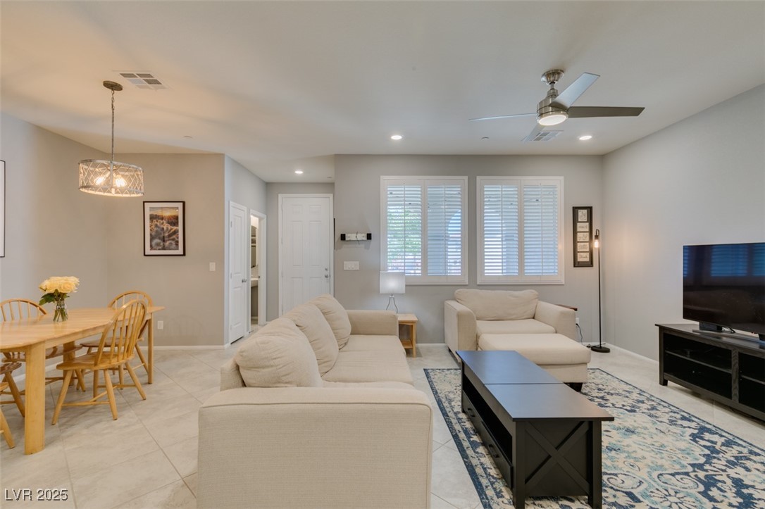 2870 Turnstone Ridge Street Henderson, NV 89044 - Photo 9 of 50 Living room with ceiling fan, recessed lighting, baseboards, light tile patterned floors, and a chandelier