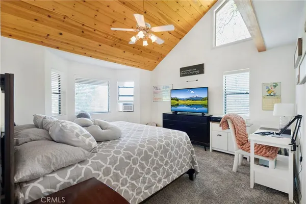 a bedroom with a bed a lounge chair and the view