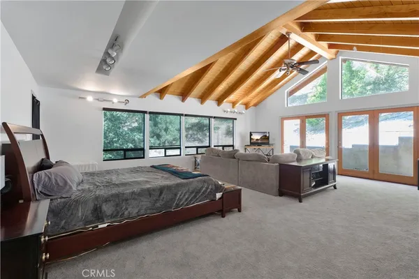 a spacious bedroom with a bed and large windows