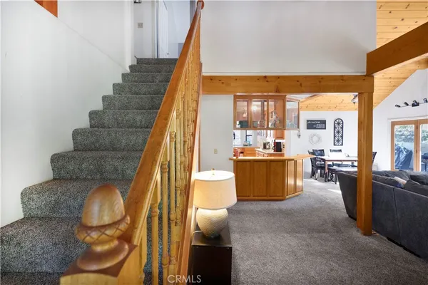 a living room with couches and kitchen view with wooden floor