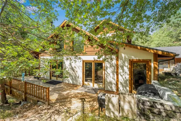 a front view of a house with a tree
