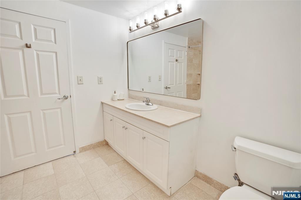 100 Old Palisade Road, Unit 2709 Fort Lee, NJ 07024 - Photo 11 of 15 a bathroom with a sink a toilet and mirror