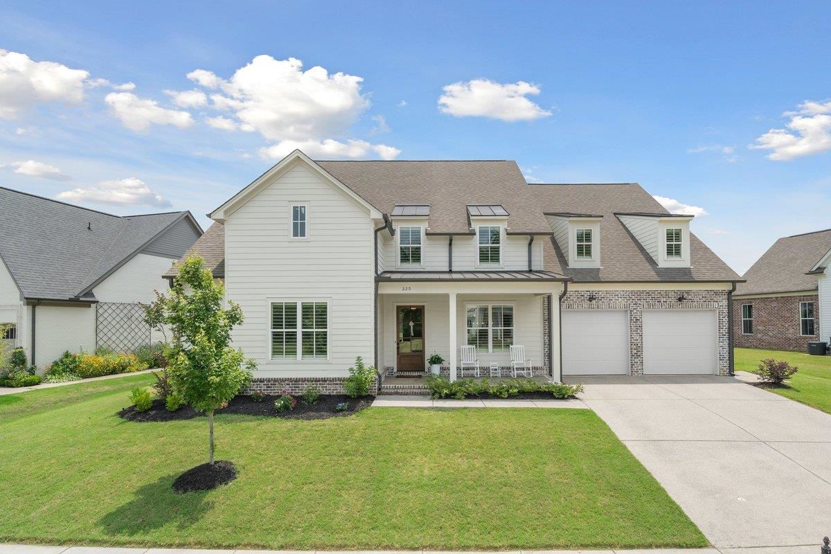 a front view of a house with a garden and yard