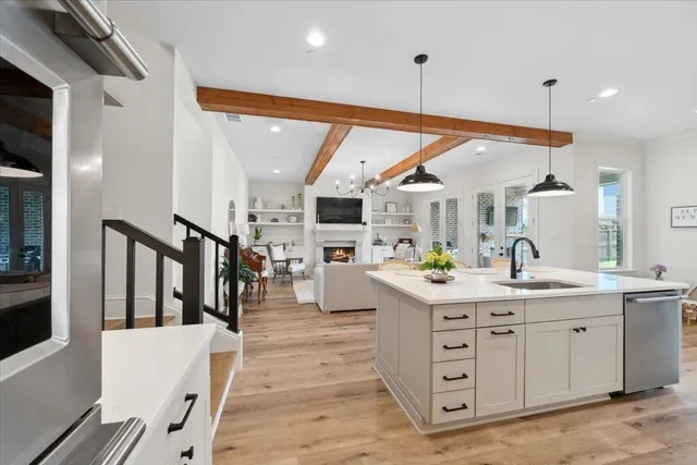 a kitchen with stainless steel appliances kitchen island granite countertop a sink and white cabinets