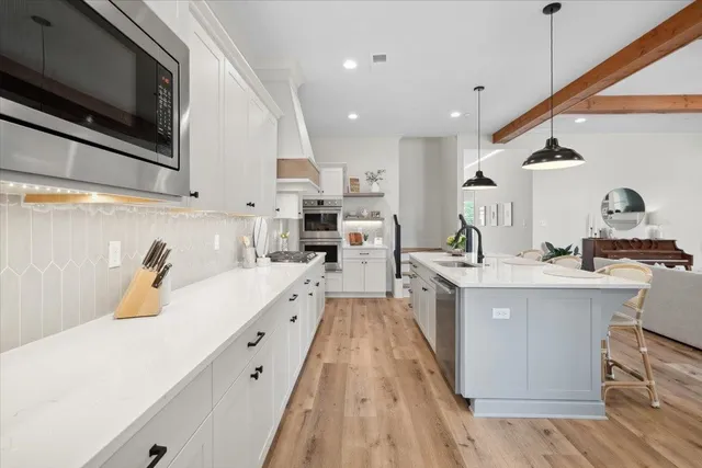 a large kitchen with stainless steel appliances kitchen island granite countertop a sink and cabinets