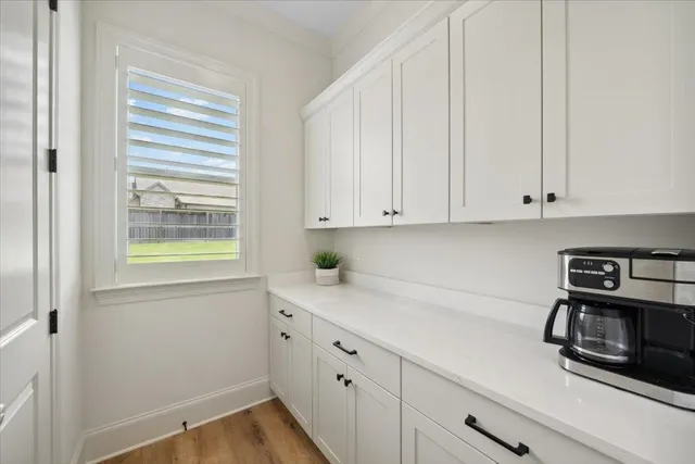 a kitchen with stainless steel appliances white cabinets and a window