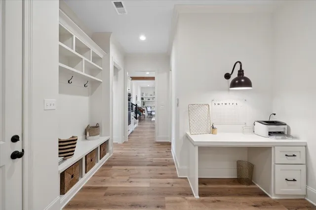 a hallway with a white stove top oven and cabinets