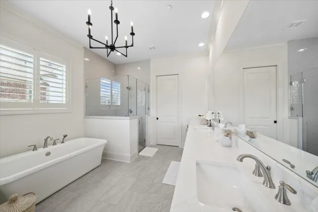 a spacious bathroom with a tub sink and mirror